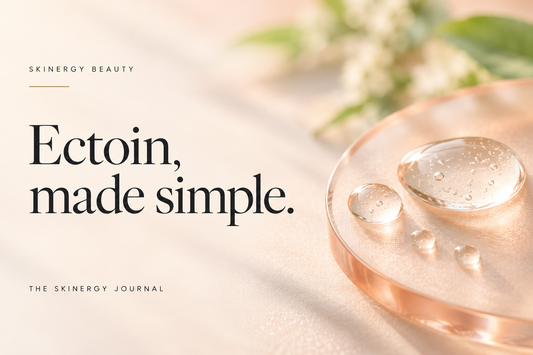 Illustrative clear serum droplets on peach glass beside Ectoin, made simple, on a Skinergy Journal cover.